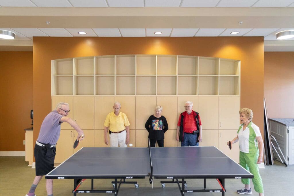 a group of seniors playing ping pong together